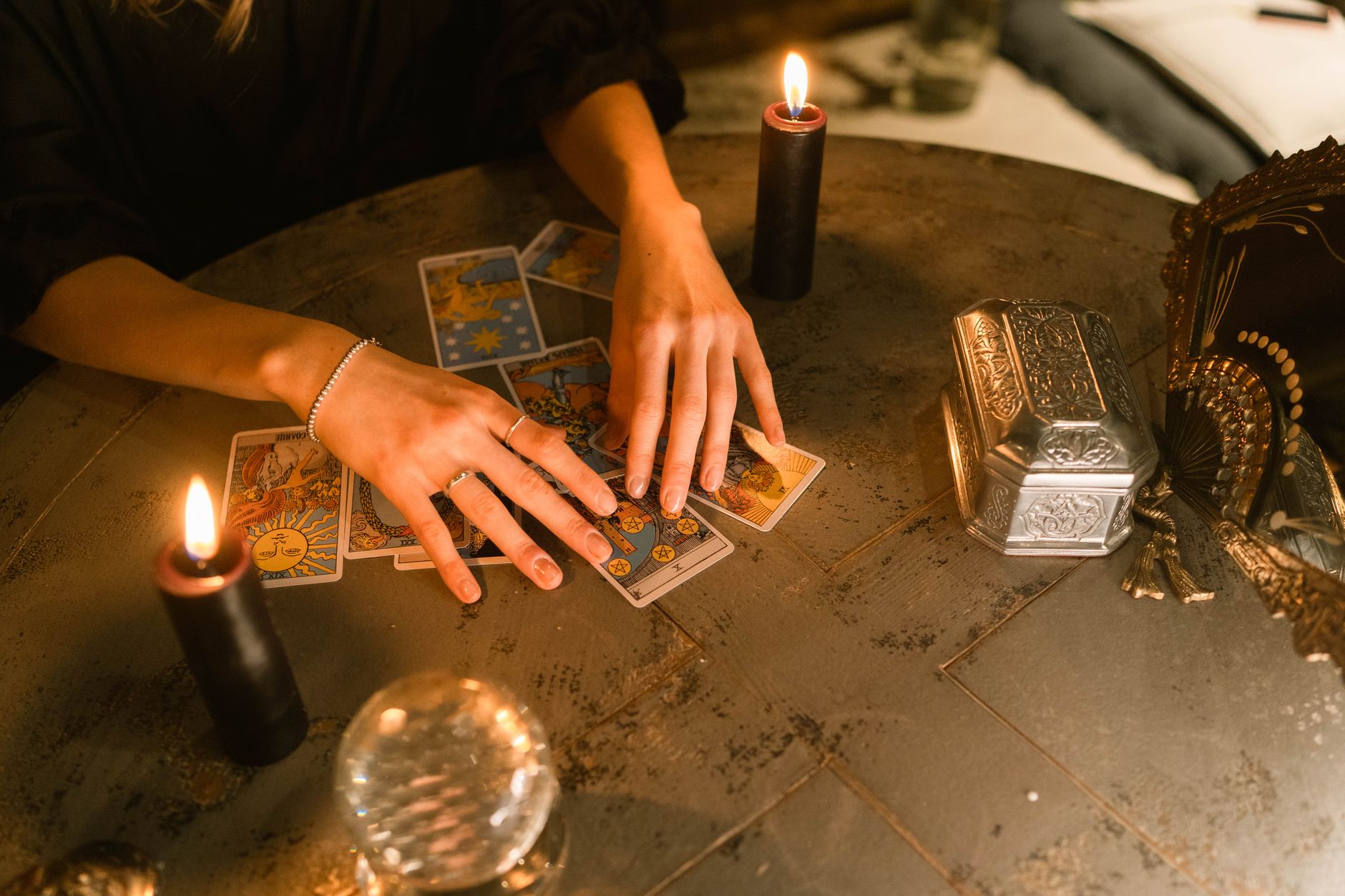Cartes de tarot et bougies sur une table.