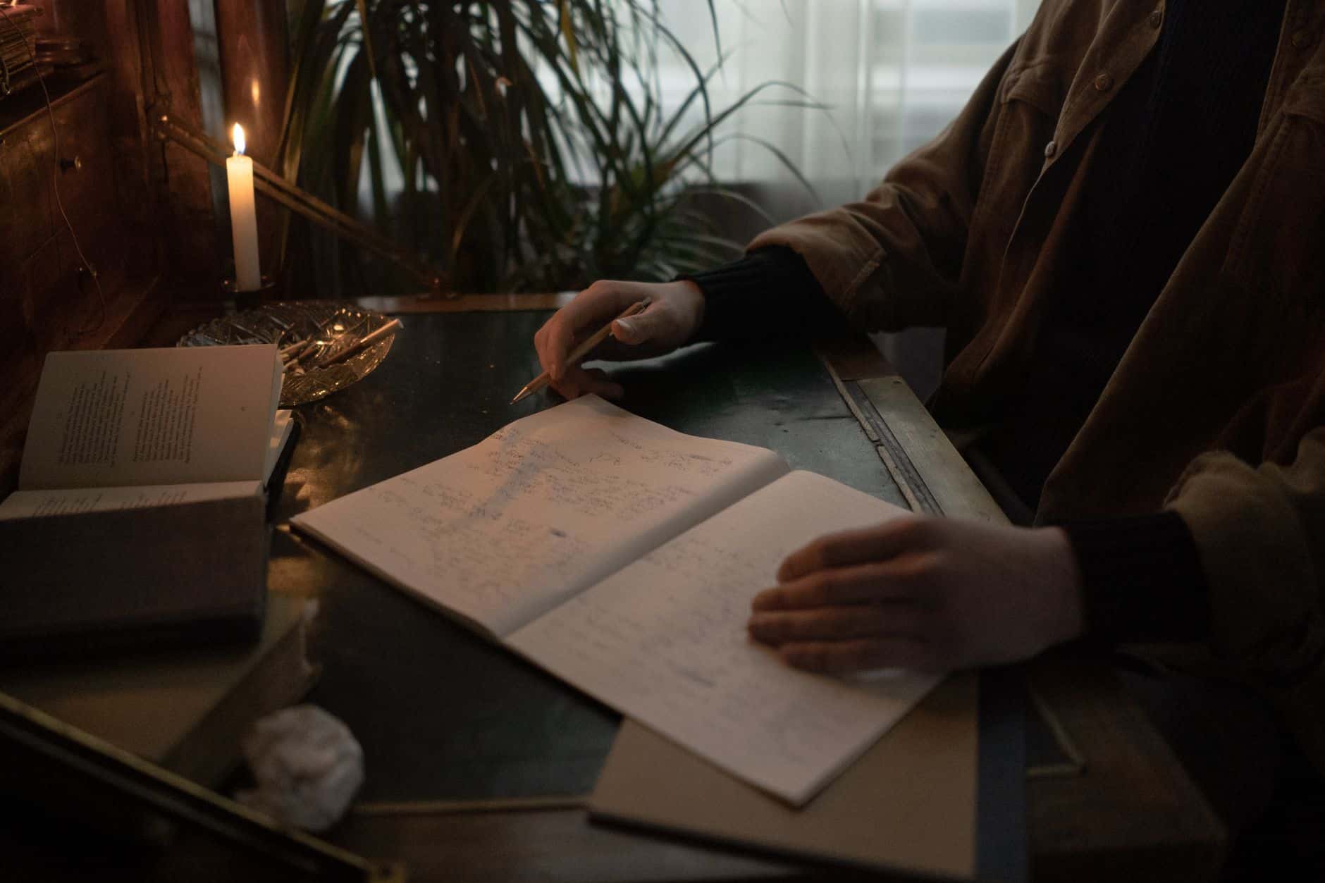 Carnet et stylo près d’une bougie.