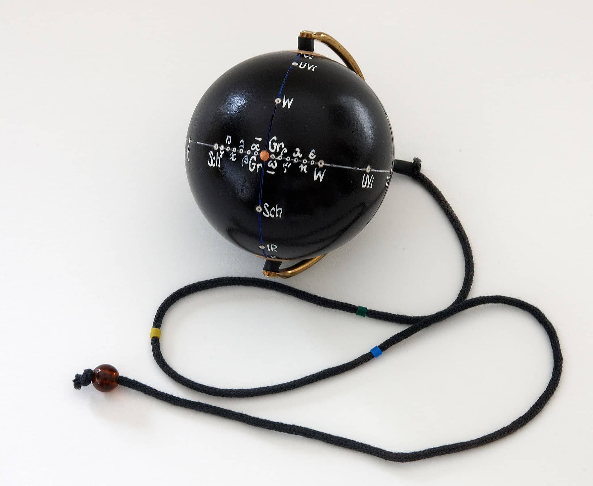Pendule ou chaine doree sur fond sombre.