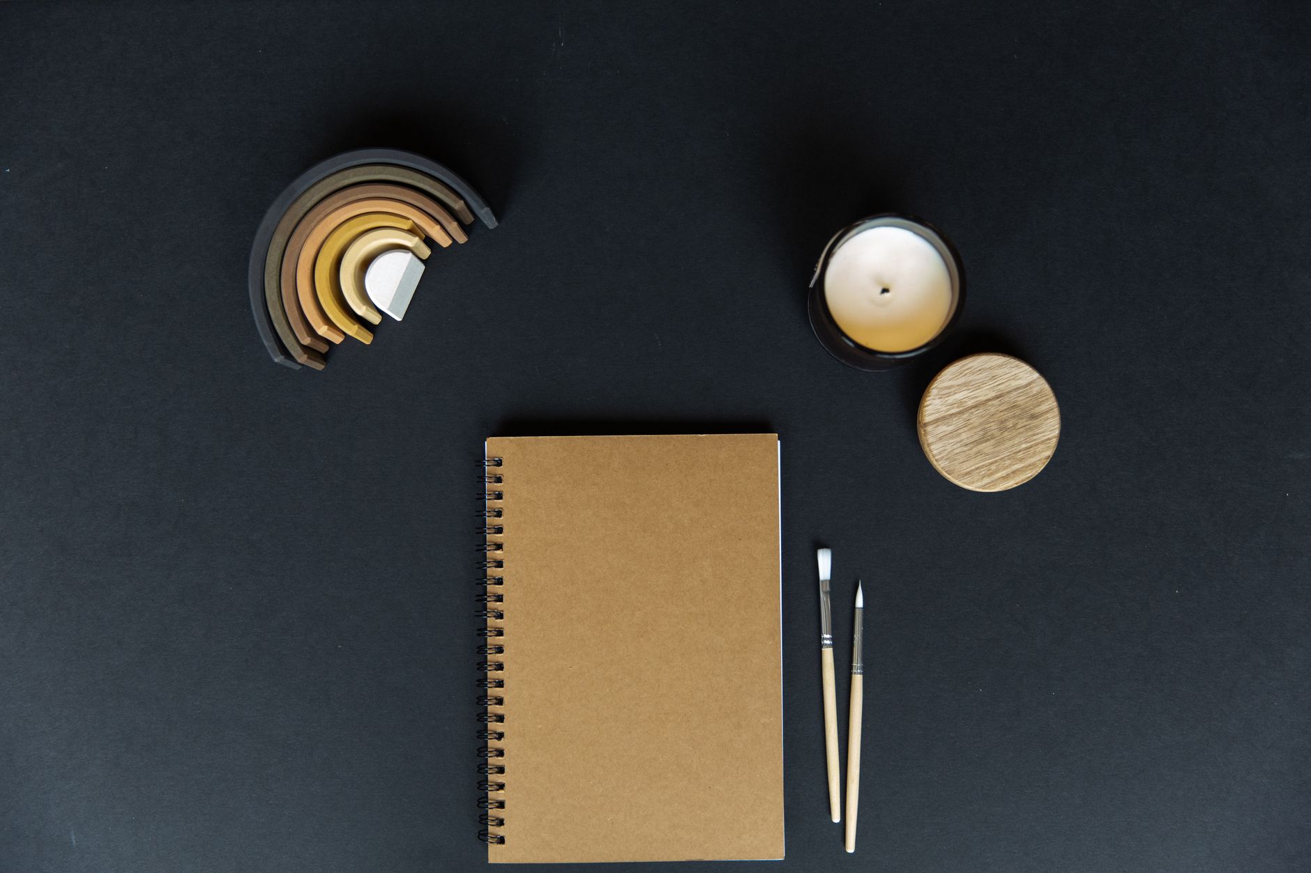 Carnet et stylo près d’une bougie.