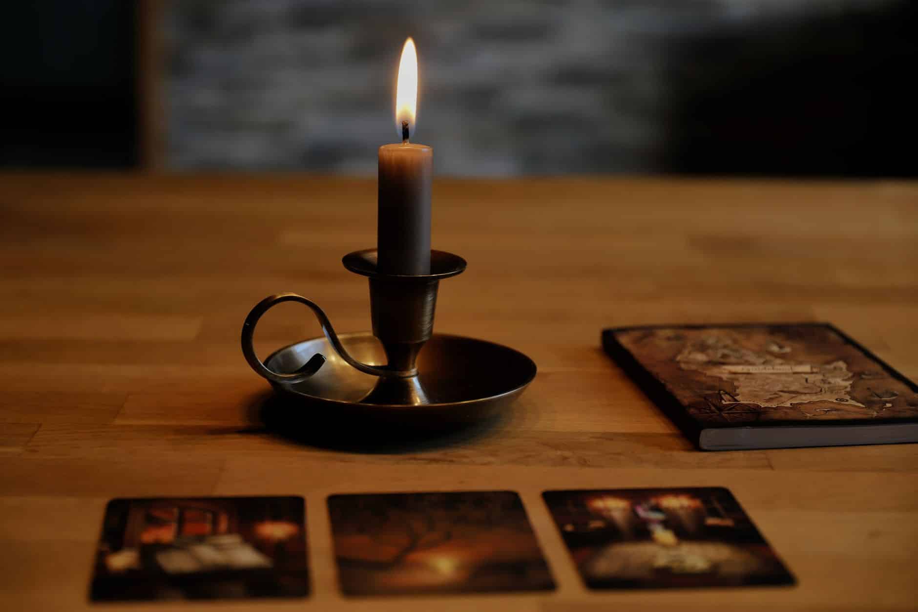 Cartes de tarot et bougies sur une table.