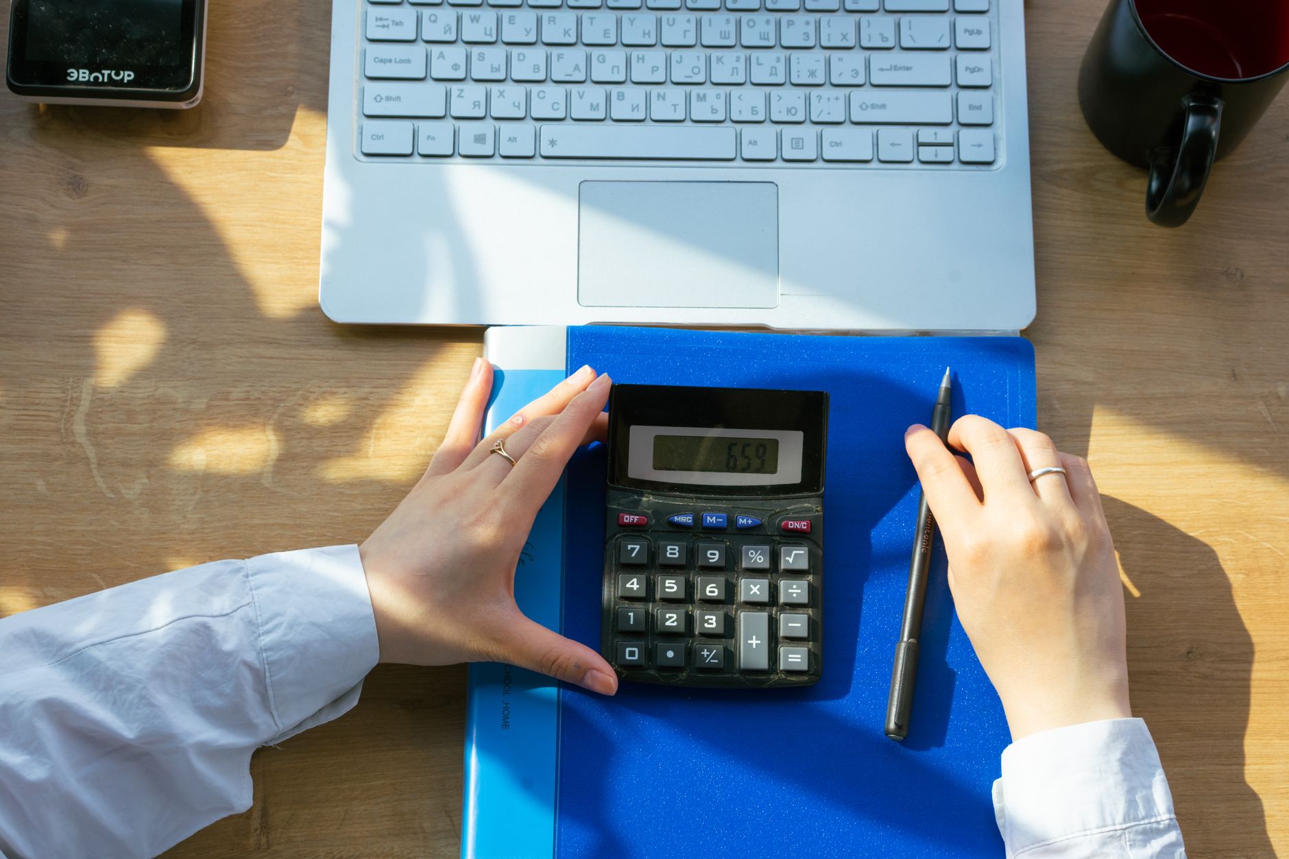Carnet, stylo et calculatrice sur un bureau.