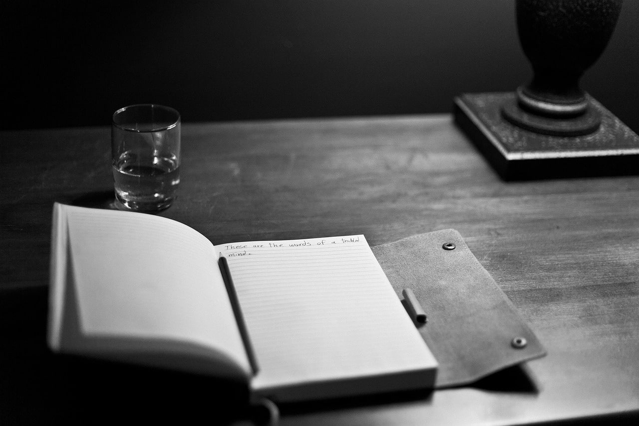 Main ecrivant dans un carnet.